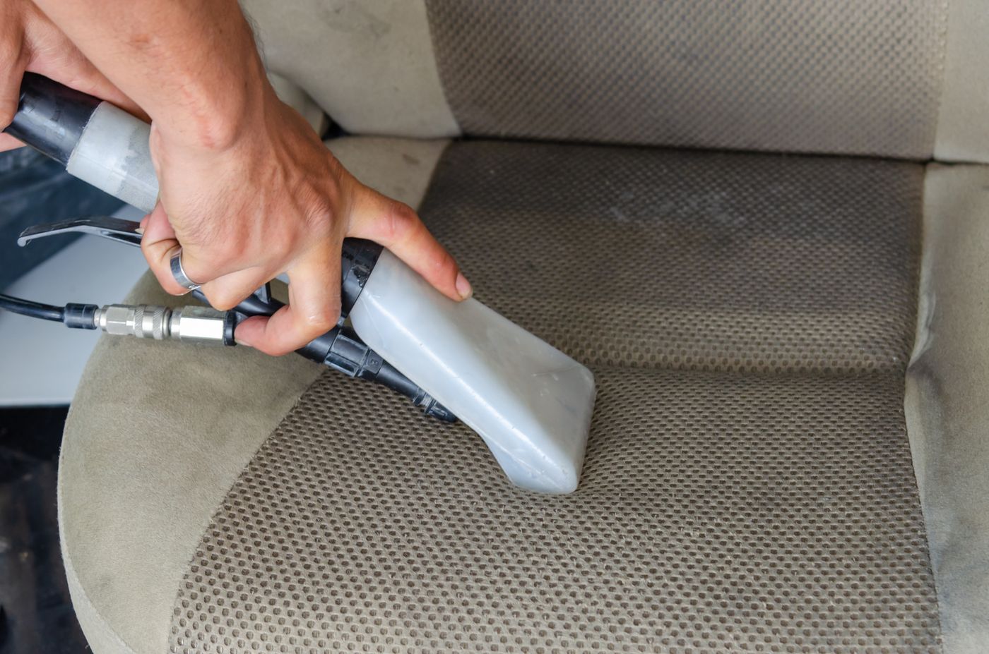 Boquilla de extracción limpiando la tapicería de un asiento de coche